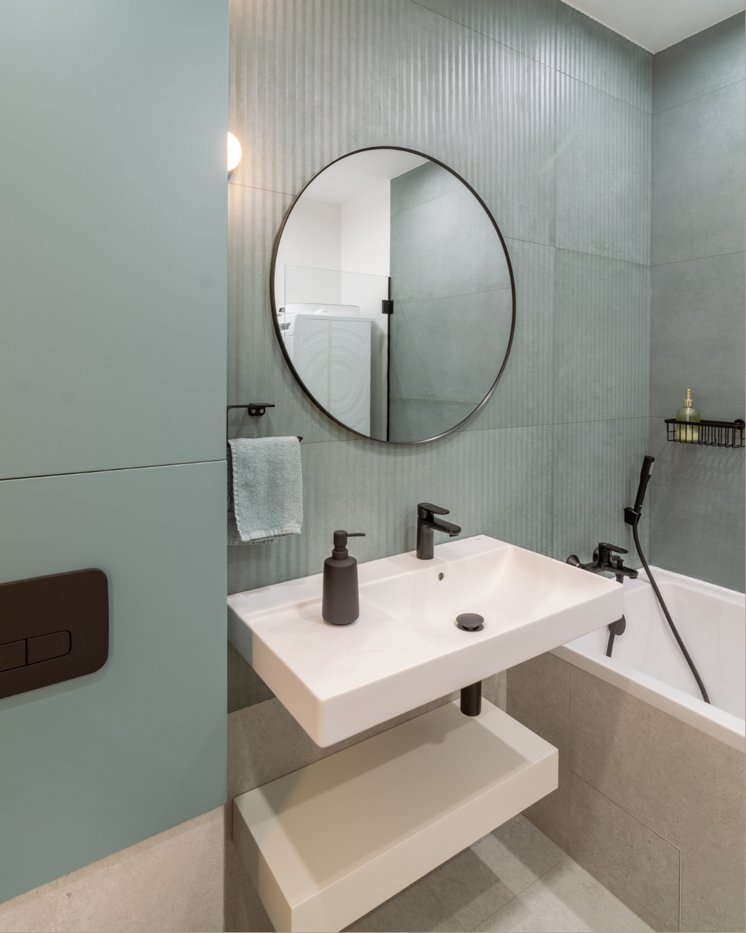 Baie minimalist cu pereți sage texturat, lavoar suspendat alb și baterii matte black — proiect semnat MAT Design, după renovare