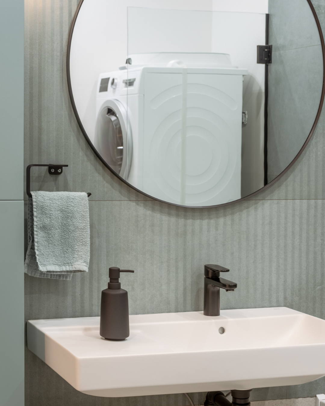 Detaliu proiect MAT Design — oglindă rotundă în cadru negru pe peretele sage